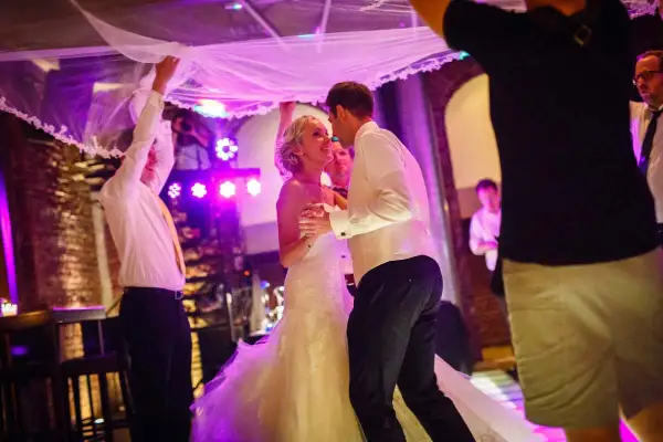 Brautpaar tanzt unter dem Brautschleier, ein romantischer Schleiertanz bei der Hochzeit.