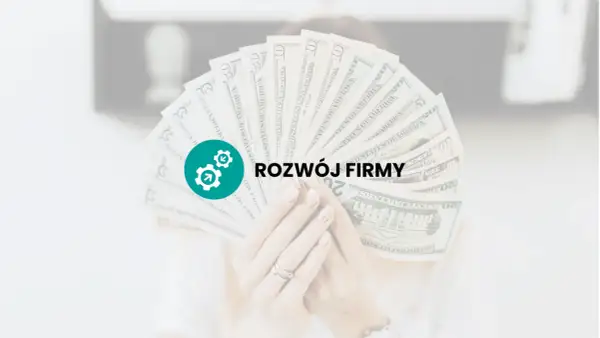 Dłoń trzyma wachlarz banknotów dolarowych z ikoną i napisem "ROZWÓJ FIRMY".