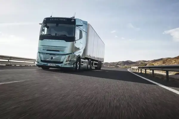 Un camion électrique Volvo roule sur une route ensoleillée, symbolisant l'autonomie et l'avenir du transport.