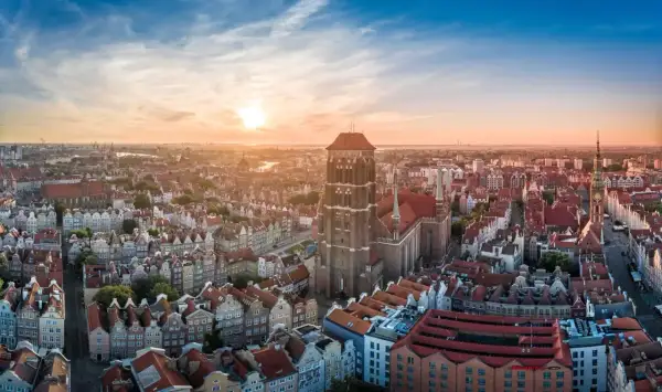Zachód słońca nad Gdańskiem, ukazujący Bazylikę Mariacką i inne trójmiasto atrakcje.