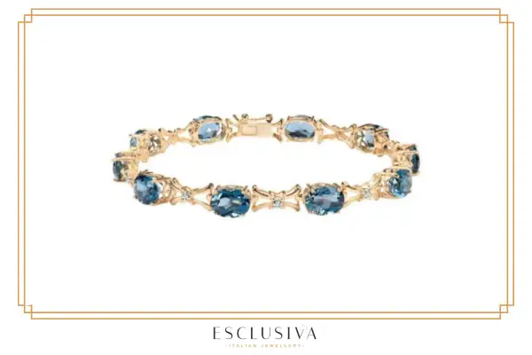 Złota bransoletka z niebieskimi kamieniami i diamentami. Taka żółta bransoletka symbolizuje elegancję i luksus.