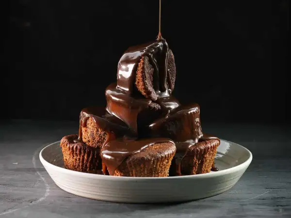 En stapel chokladmuffins, rikligt täckta med varm chokladsås. Ett perfekt sticky toffee pudding recept för fikat.