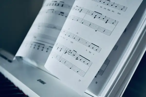 Otwarta księga nut na pianinie. Mario, czy ty wiesz, jak zagrać te nuty? PDF z muzyką czeka.