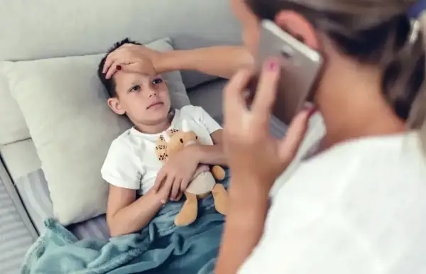 Chora l4 na dziecko, mama sprawdza temperaturę i dzwoni po pomoc.