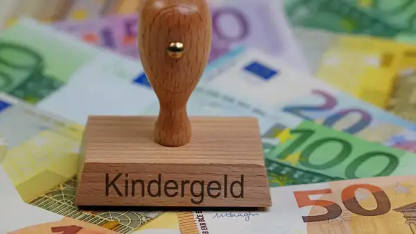 Stempel z napisem "Kindergeld" na tle banknotów euro. To symbol wsparcia dla rodzin, jak 500+.
