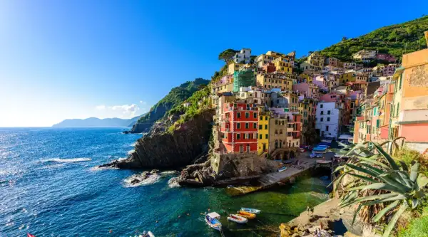 Riomaggiore, uno dei i 10 borghi più belli della Liguria, con le sue case colorate a picco sul mare blu.
