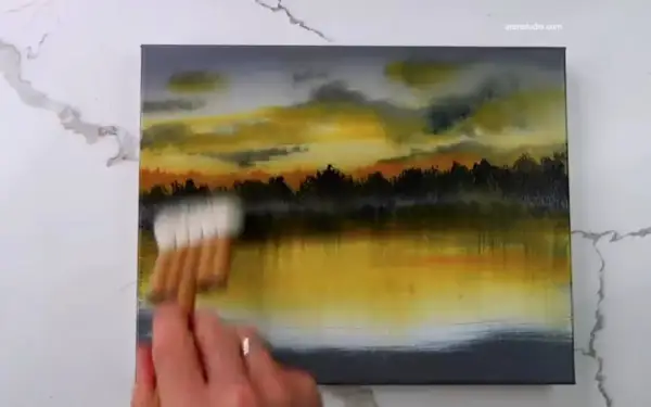 Peinture au scotch d'un paysage au coucher du soleil, avec des nuages orangés et jaunes reflétés dans l'eau.