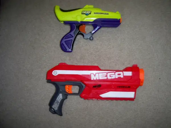 Dwa pistolety Nerf: żółto-fioletowy i czerwony Nerf Magnus.
