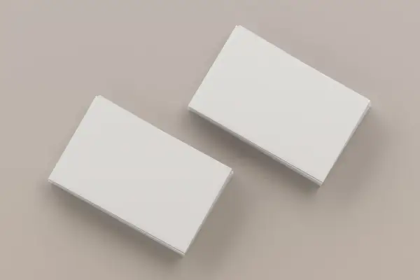 Dwie stosy białych wizytówek na neutralnym tle. Idealne do nauki, jak wydrukować wizytówki.