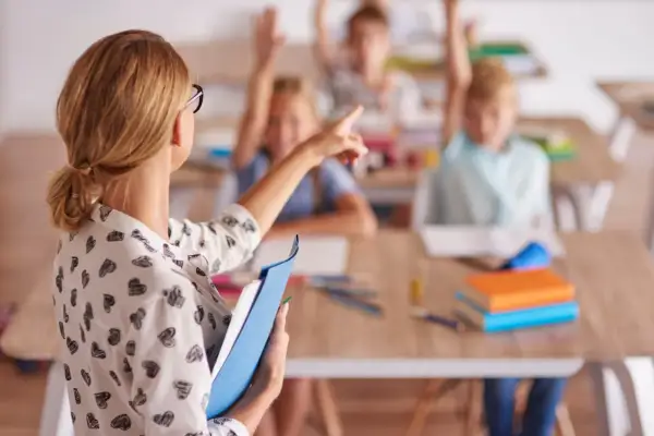 Nauczycielka wskazuje na ucznia, który podniósł rękę. Dzieci chętnie odpowiadają, jakby to był ich urlop uzupełniający.