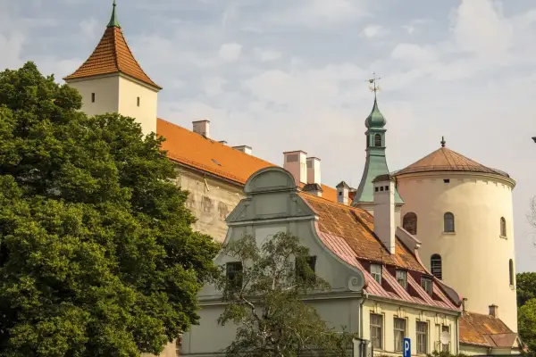Historyczne budynki, w tym wieża i okrągła baszta, tworzą malowniczy krajobraz. Wśród nich znajduje się dom bractwa czarnogłowych.