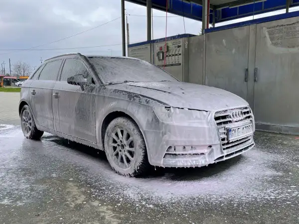 Szary Audi w pianie, gotowy do mycia samochodu na samoobsługowej myjni.