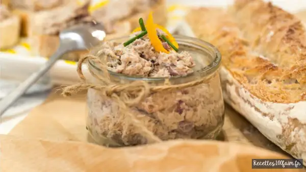Un pot de rillettes de sardines, garni d'une touche d'agrume et de ciboulette, à déguster avec une baguette croustillante.