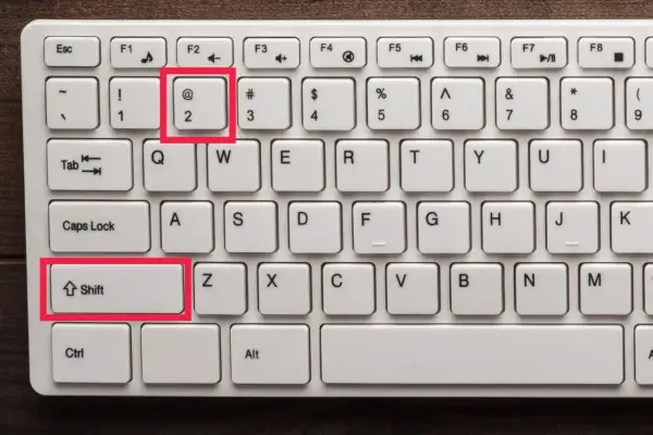 Klawiatura z zaznaczonymi klawiszami Shift i 2 (@). Chcesz wiedzieć, jak zrobic małpe na laptopie?