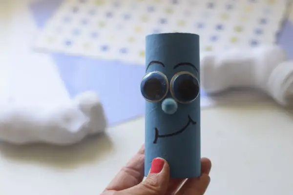 Un pitufo filósofo, dibujo hecho con un rollo de papel azul, ojos saltones y una sonrisa pensativa.