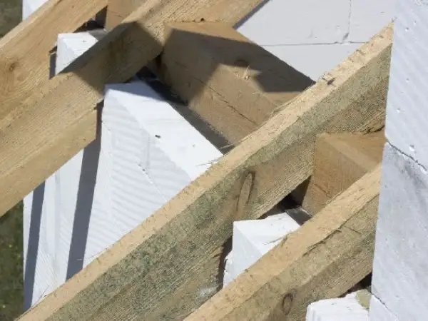 Drewniana konstrukcja dachu z elementami białego betonu komórkowego. To właśnie murłata, co to jest? To belka opierająca się na ścianie szczytowej.