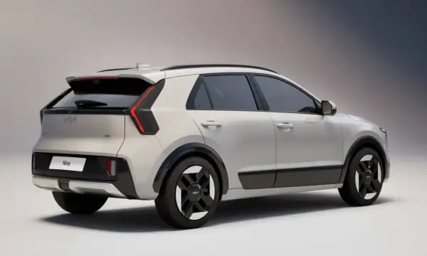 Nowy Kia Niro w kolorze jasnoszarym, widok z tyłu i boku. Stylowe światła LED i czarne detale podkreślają nowoczesny design.