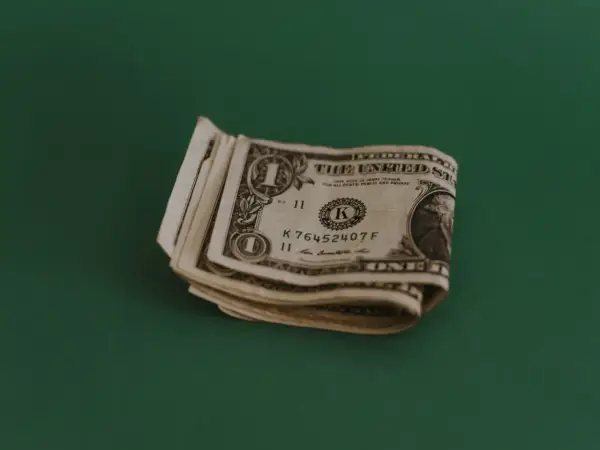 Kilka banknotów jednodolarowych leży na zielonym tle. Zastanawiasz się, jaki napiwek w restauracji zostawić?