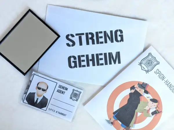 Spannende Detektiv Geburtstag Ideen: Ein Spiegel, ein Ausweis als "Geheim Agent" und eine Broschüre mit dem Titel "Spion-Handbuch" versprechen einen geheimen Missionstag.