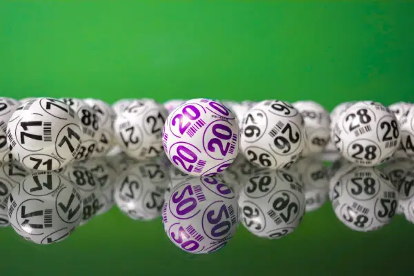 Kulki lotto na zielonym tle. Wygrana w lotto to szansa na bezpieczne inwestowanie pieniędzy i realizację marzeń.