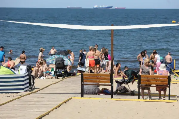 Plaża w Gdańsku tętni życiem. Ludzie kąpią się, opalają i spacerują. To idealne miejsce na relaks i odkrywanie gdańskich atrakcji dla dorosłych.