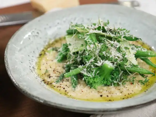 Krämig risotto med grönsaker, toppad med parmesan och färska örter. Ett perfekt risotto recept för en lätt lunch.