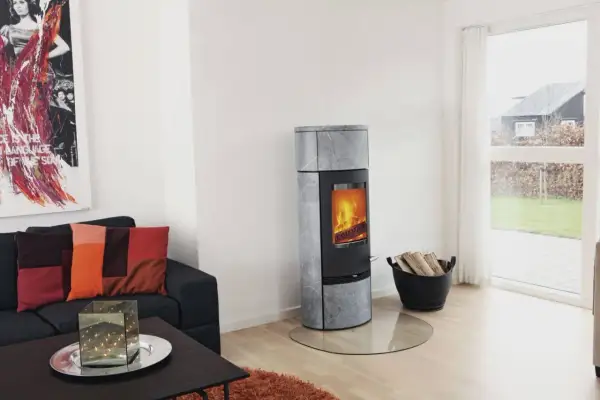 Un poêle à bois moderne, idéal pour installer un poêle à bois dans une maison sans conduit, chauffe agréablement le salon.