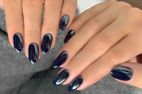 Manucure noir aux reflets métalliques, des ongles élégants et modernes.