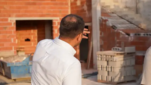 Un arquitecto supervisa la construcción de una casa, evaluando cuánto vale un arquitecto para construir una casa.