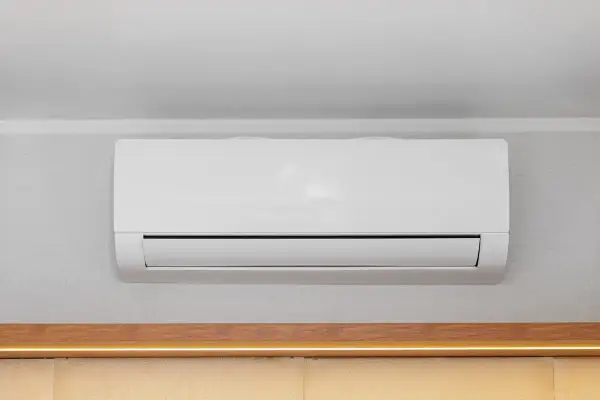 Unità interna di condizionatore bianco montata a parete, con canalina nascosta per un'installazione pulita.
