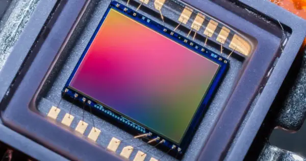 Sensore di immagine 576 megapixel con sfumature arcobaleno, collegato da sottili fili dorati a contatti metallici.