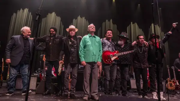 Zespół muzyczny na scenie, w tym Bill Murray w zielonej koszuli, gotowy na koncerty.