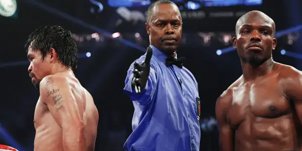 Referee signals between boxers, hinting at a close fight that could end in a majority decision vs split decision.