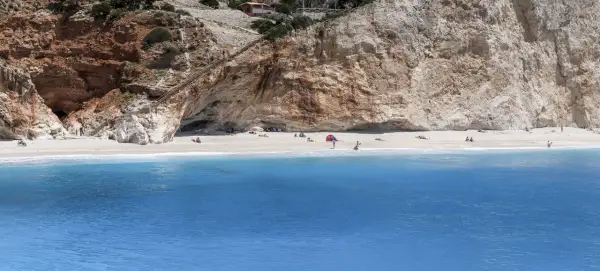 Piękna plaża Porto Katsiki z turkusową wodą i stromymi klifami. Schody prowadzą do jaskini.
