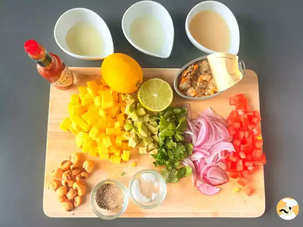 Mise en place para ceviche: mango, aguacate, cebolla morada, tomate, cilantro, limón, lima, mejillones en lata, maíz tostado, Tabasco y líquidos.