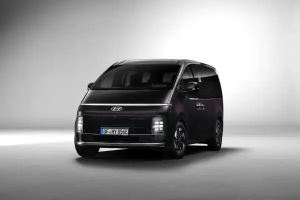 Ciemny Hyundai Staria z charakterystycznym pasem świateł LED na przodzie, gotowy na rodzinne podróże.