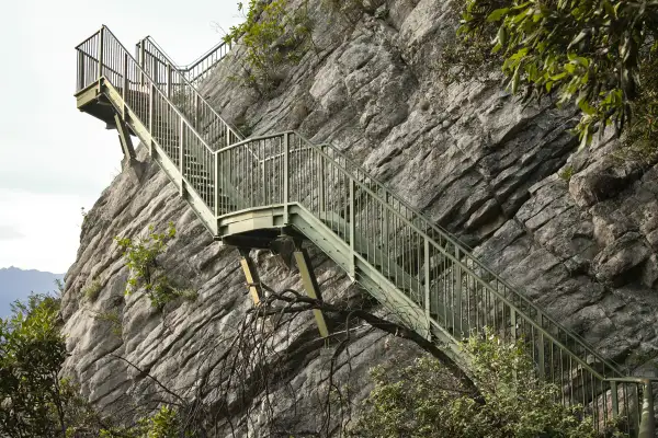 Scalinata metallica aggrappata alla roccia, un sentiero a Torbole che sfida la tempesta.
