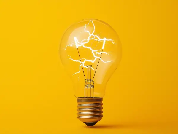 Żarówka z błyskawicami w środku, symbolizująca energię i pomysł. Jak obliczyć moc? To pytanie, na które odpowiedź może rozjaśnić umysł.