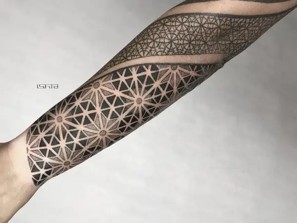 Geometryczny tatuaż dotwork na przedramieniu, tworzący hipnotyzujący wzór z trójkątów i kropek.
