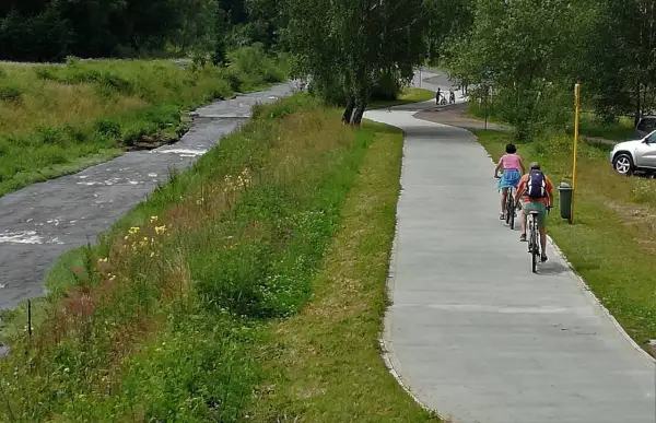 Rowerzyści cieszą się malowniczą trasą velo Krynica wzdłuż rzeki.