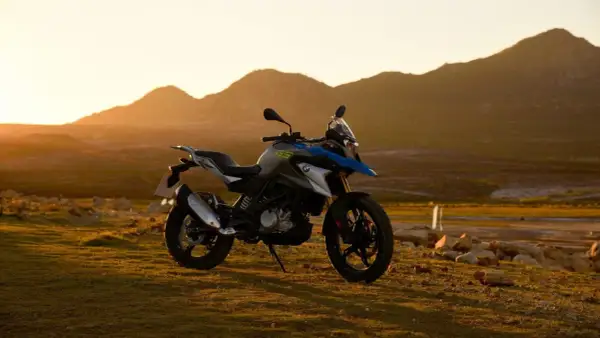 Motocykl BMW GS 310 na tle gór o zachodzie słońca.