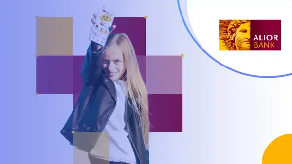 Uśmiechnięta dziewczyna prezentuje telefon z aplikacją Alior Bank. To idealne konto dla dziecka, które uczy się finansów.