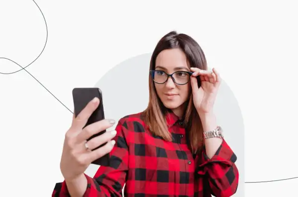 Kobieta w okularach robi sobie selfie telefonem. Czy zdjęcie do dowodu może być w okularach? Tak, jeśli nie zasłaniają twarzy.