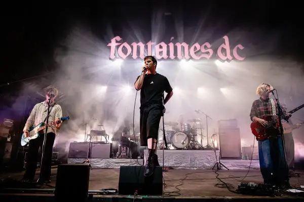 Fontaines D.C. live in Stuttgart, mit Sänger im Scheinwerferlicht und Band auf der Bühne.