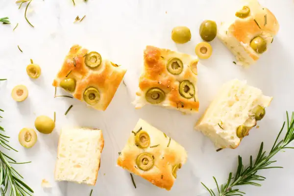 Odkryj oryginalna włoska focaccia przepis! Puszyste kromki z oliwkami i rozmarynem, idealne na przekąskę.