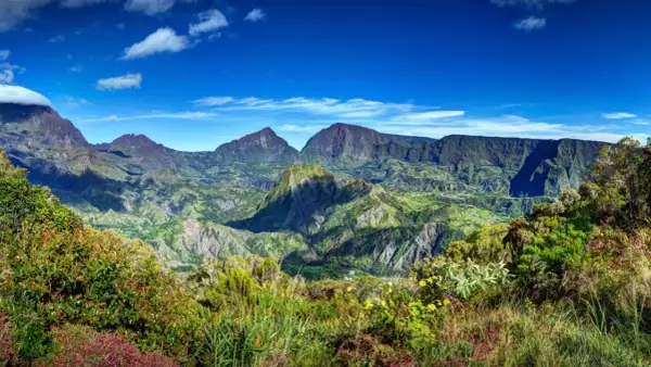 Paysage montagneux verdoyant sous un ciel bleu. Idéal pour réfléchir à que faire à la Réunion.