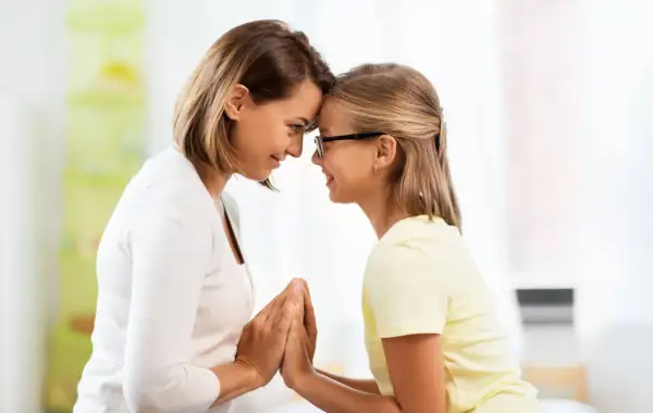 Madre e figlia si guardano con affetto, le fronti unite. Un momento di connessione profonda, che a volte può nascondere la psicologia di una madre invidiosa della figlia.