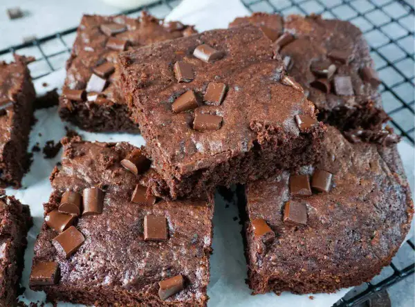 Saftige Zucchini-Brownies mit Schokoladenstückchen, die auf einem Gitterrost liegen.