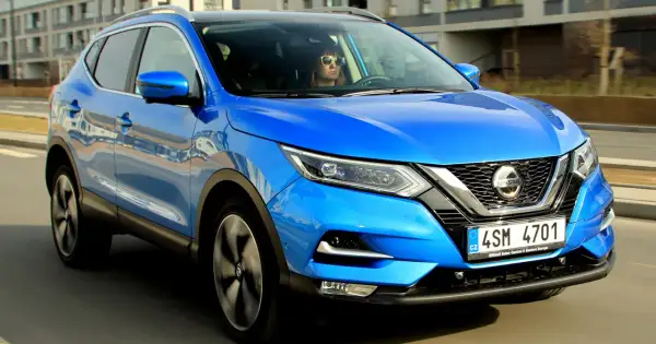 Niebieski Nissan Qashqai w ruchu. Kierowca w okularach przeciwsłonecznych. Sprawdź nissan qashqai wymiary.