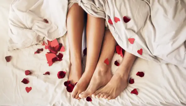 Nogi pary pod kołdrą, wśród płatków róż i serduszek. Czy to początek romansu, czy może sex z przypadku?